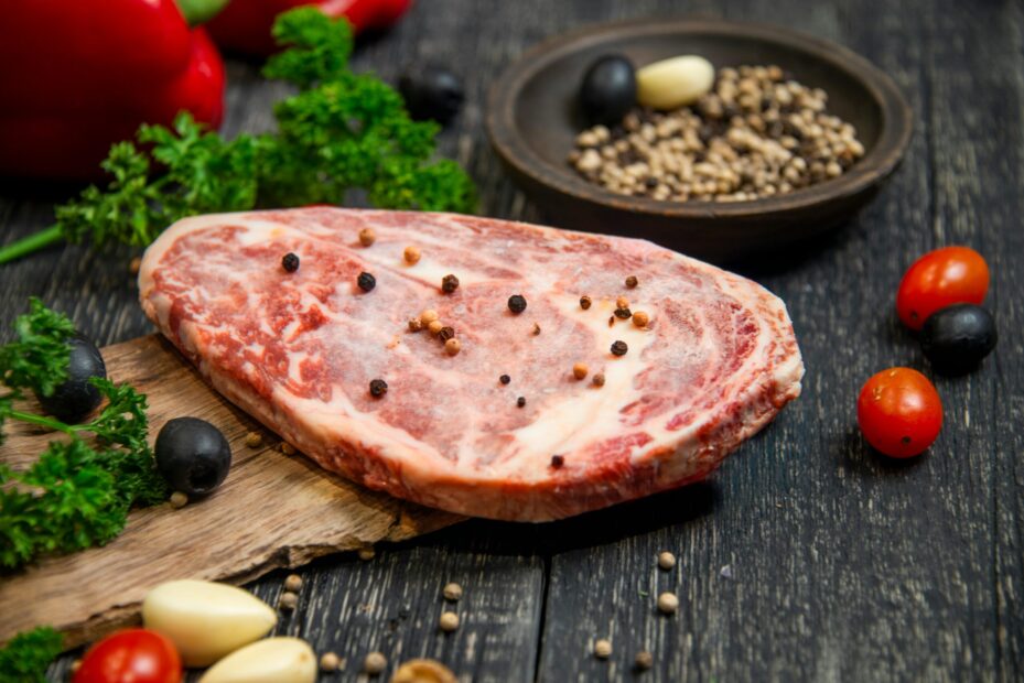 Raw meat with vegetables on a table.