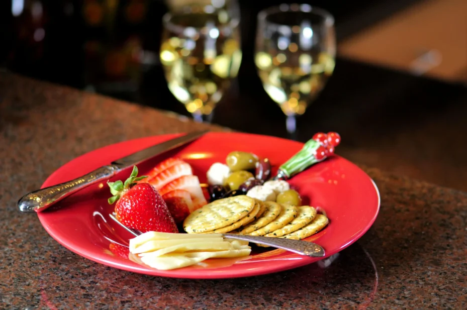 A plat of cheese, crackers and fruit.