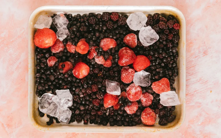 A half-sheet pan full of frozen berries and fruit.