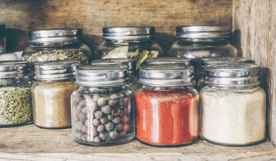 A group of mason jars holding dried items.