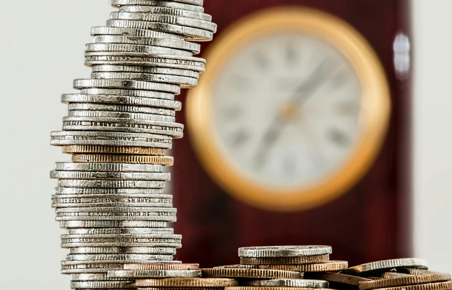 A stack of coins and a clock.